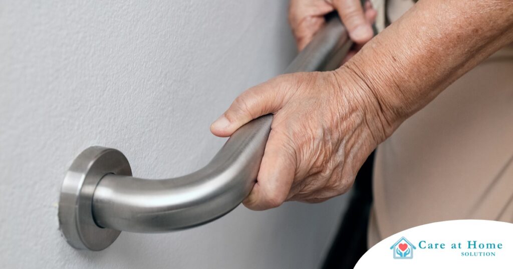 An older adult uses a grab bar representing one of the home modifications that is helpful for fall prevention for elderly adults.